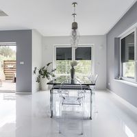 Modern living room with many windows and transparent plastic chairs